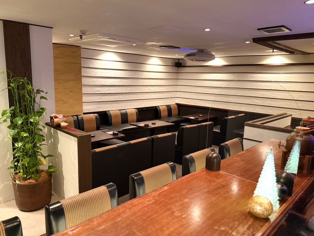 白い壁と濃い木部、カウンターとボックス席があるマーレクスの店内